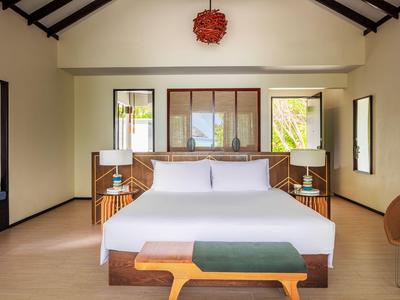 Nowoczesny pokój hotelowy z dużym łóżkiem, drewnianą ramą i stylową dekoracją.