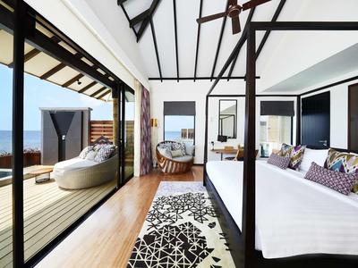 Camera d'hotel moderna con vista aperta sulla terrazza e sul mare.