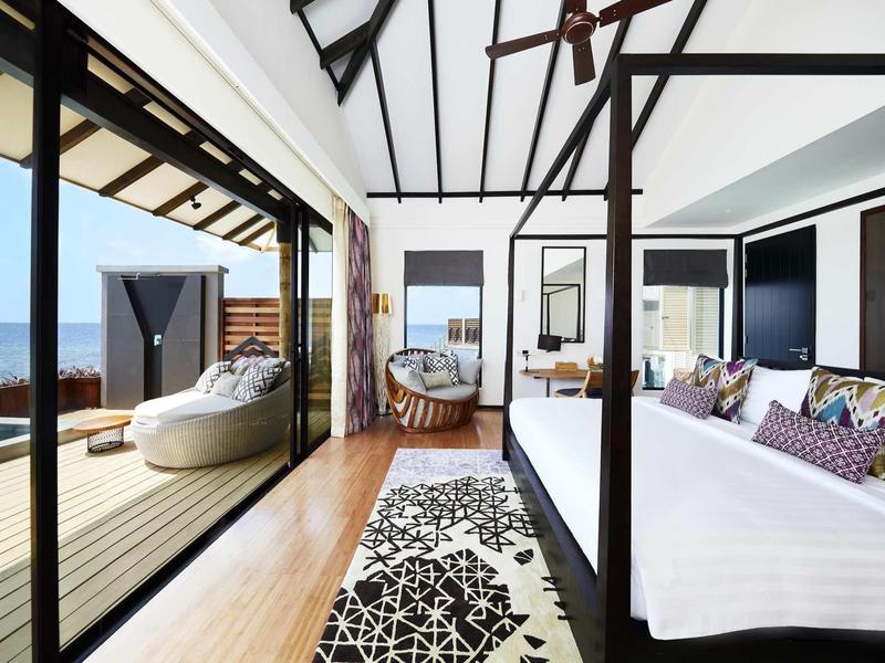 Camera d'hotel moderna con vista aperta sulla terrazza e sul mare.