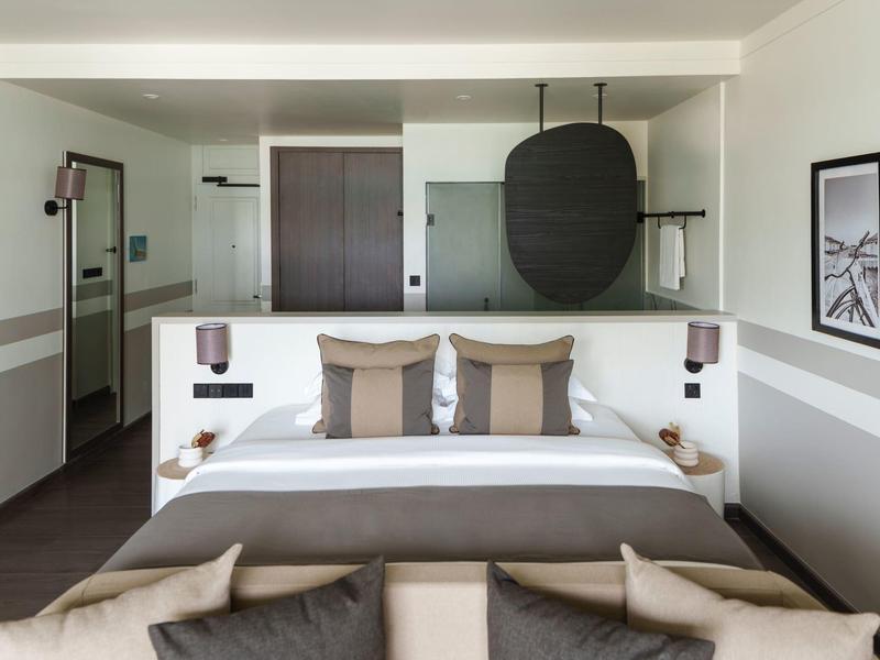 Camera d'hotel moderna con letto matrimoniale, cuscini accoglienti e decorazioni murali eleganti.