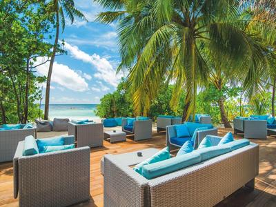 Moderner Außenbereich mit Sofas und Blick auf tropischen Strand und Meer