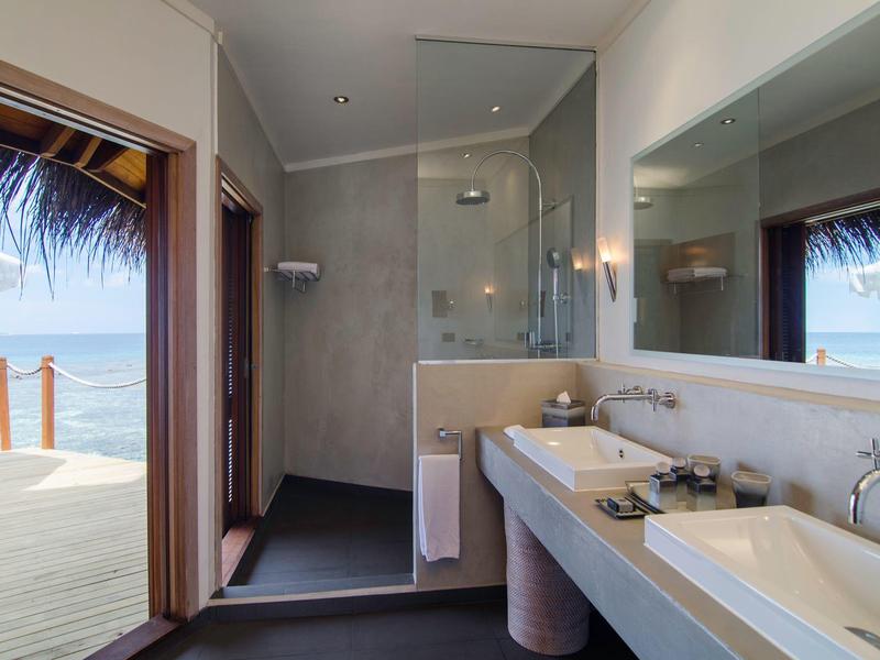 Modernes Badezimmer mit zwei Waschbecken und Blick auf Terrasse und Meer