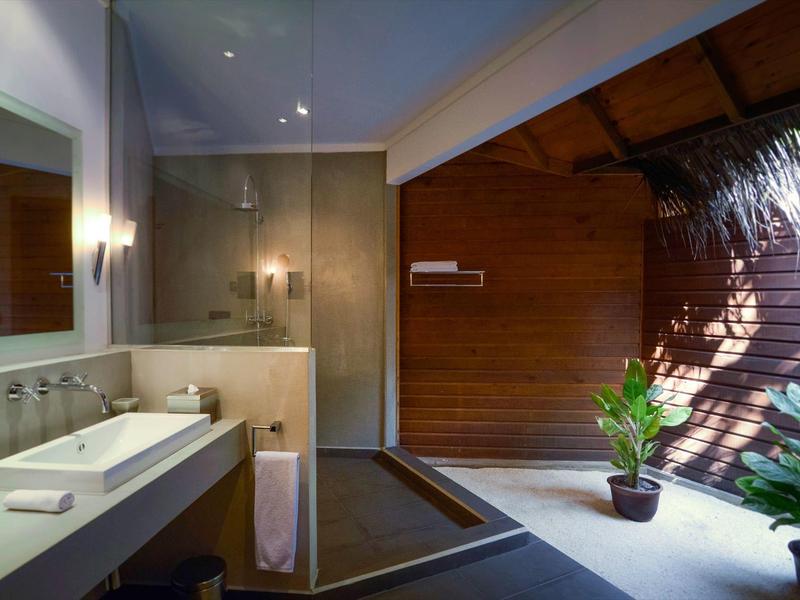 Modernes Badezimmer mit Dusche, Waschbecken und Pflanzen in natürlichem Licht