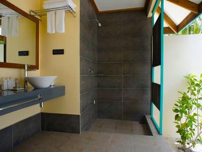 Modernes Badezimmer mit großem Spiegel, zwei Waschbecken, grauen Fliesen und offener Dusche.