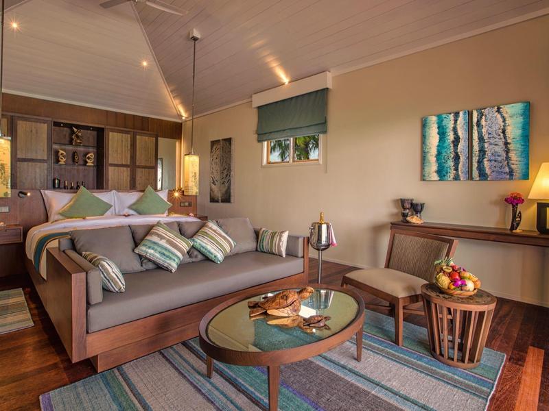 Soggiorno accogliente con divano, tavolino, tappeto e illuminazione decorativa calda.