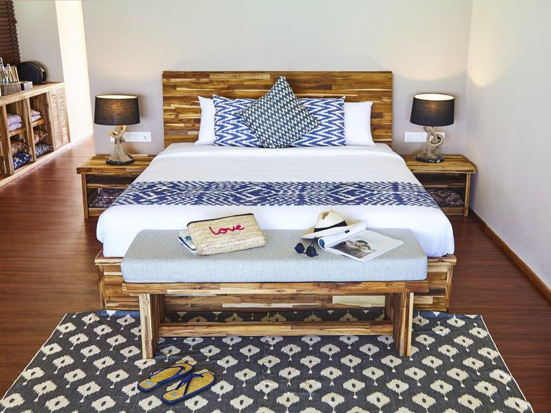 Pokój hotelowy z podwójnym łóżkiem, lampkami nocnymi i wzorzystym dywanem.