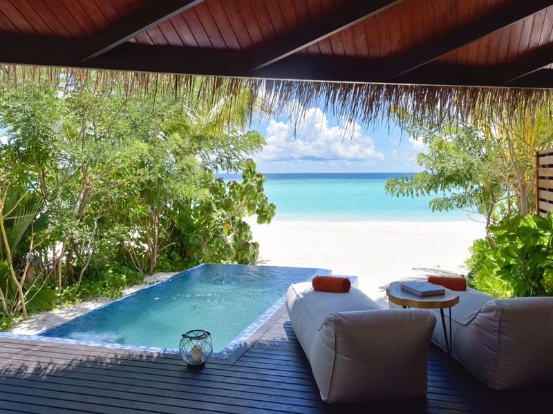 Vue d'une terrasse couverte avec piscine sur plage tropicale et mer