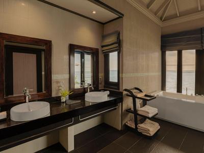 Modernes Badezimmer mit Doppelwaschbecken, Badewanne und großen Fenstern mit Blick auf eine helle Landschaft.