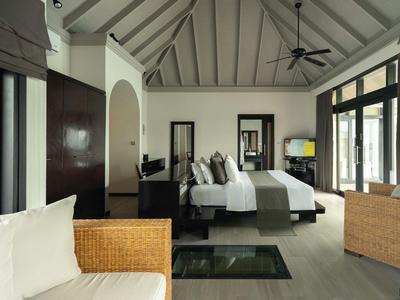 Modern eingerichtetes Hotelzimmer mit großen Fenstern und gemütlichem Sofa.