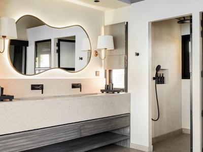 Modernes Badezimmer mit Doppelwaschbecken, großem Spiegel und offener Duschnische.