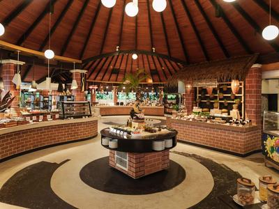 Moderne Bäckerei mit Rundtheke, Backwaren und Holzdecke in einem runden Raum.