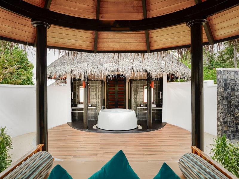 Vista de una ducha al aire libre en una villa de hotel de lujo con terraza de madera y área privada.