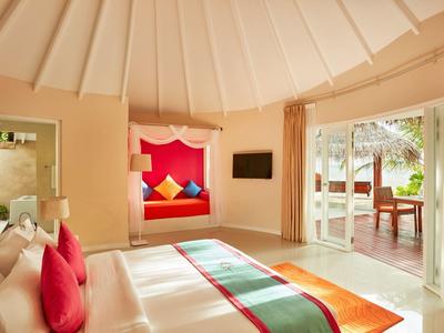 Helle Hotelzimmer mit gemütlichem Bett, eingebautem Sitzbereich und Zugang zur Terrasse.