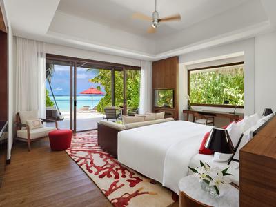 Nowoczesny pokój hotelowy z podwójnym łóżkiem, widokiem na morze i tarasem przez duże okna.