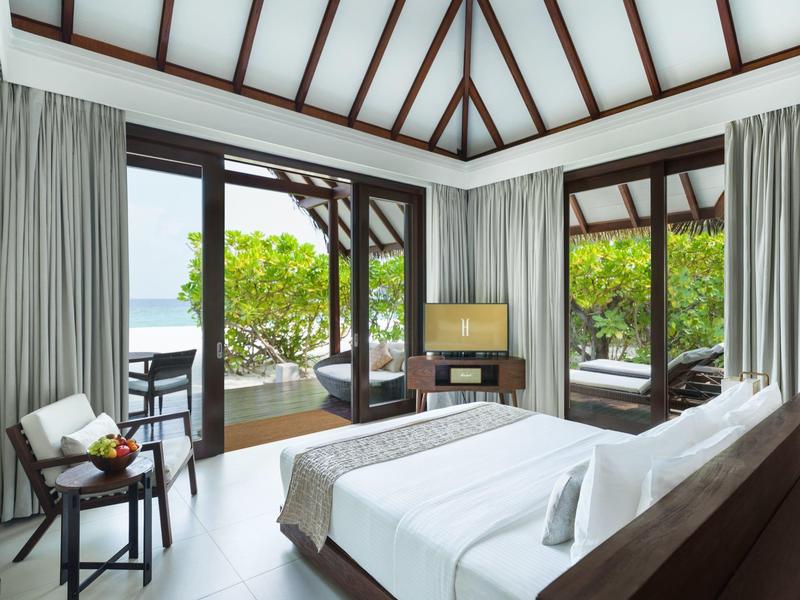 Nowoczesny pokój hotelowy z dużym łóżkiem i tarasem z widokiem na morze.