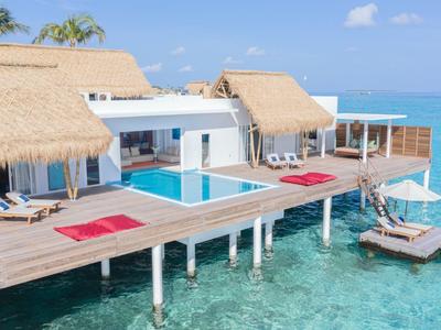Luxuriöse Wasserbungalows mit Holzsteg, Pool und direktem Zugang zum türkisfarbenen Meer.