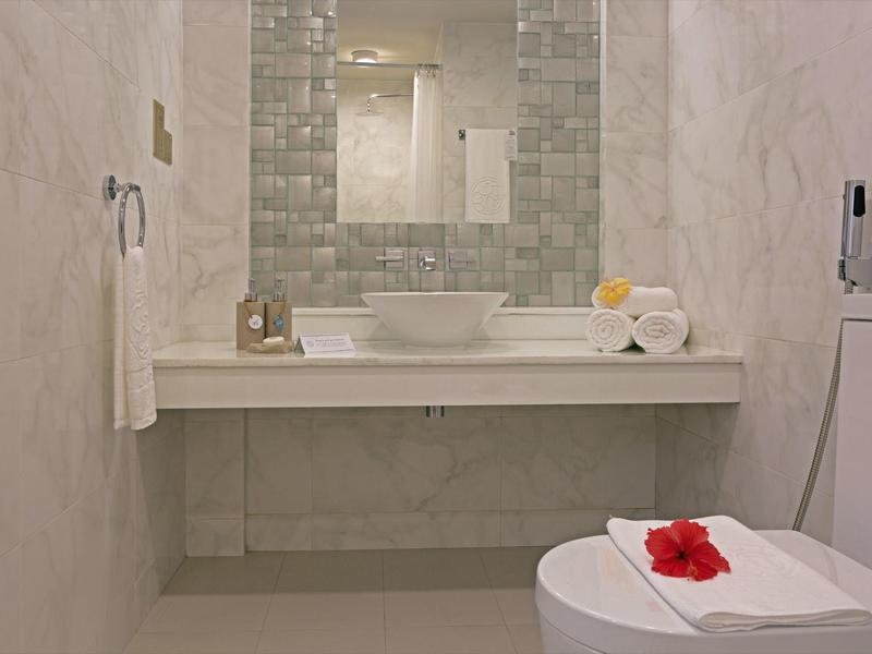 Moderne badkamer met wastafel, grote spiegel en toiletruimte.