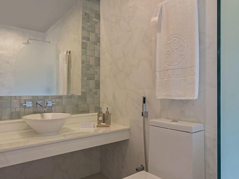 Moderne badkamer met grijs marmer, witte wasbak en toilet met een rode bloem.