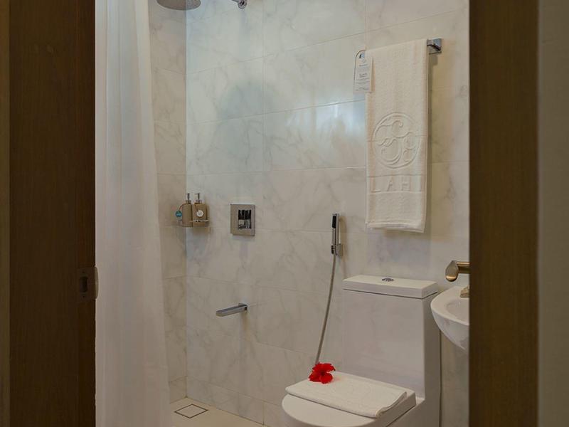 Compacte badkamer met toilet, douchegordijn en handdoek aan de muur.