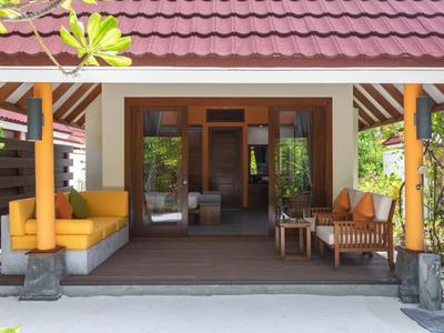 Accogliente terrazza coperta con area salotto e divano davanti a una camera d'albergo