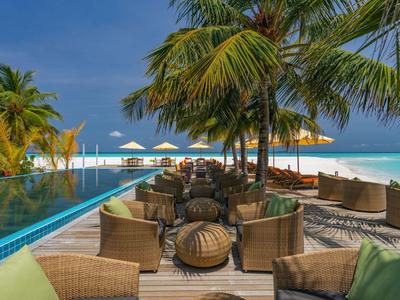 Luxuriöser Außenbereich mit Sitzgelegenheiten, Pool und Blick auf den Strand und das Meer.