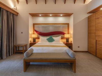 Camera d'hotel moderna con mobili in legno e letto accogliente in toni caldi.