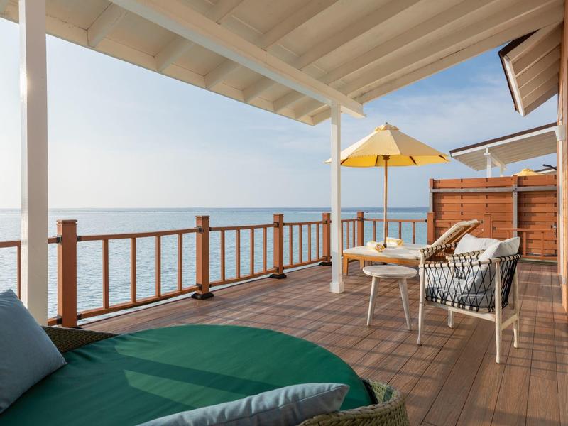 Terrazza coperta con area salotto e vista sul mare sotto un cielo sereno.