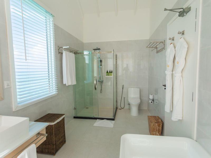 Bagno luminoso con doccia, WC, vasca, asciugamani e accappatoi in hotel