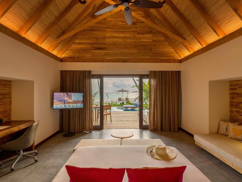 Helles, modernes Zimmer mit Holzdach, Schreibtisch, TV, Balkon und Poolblick.