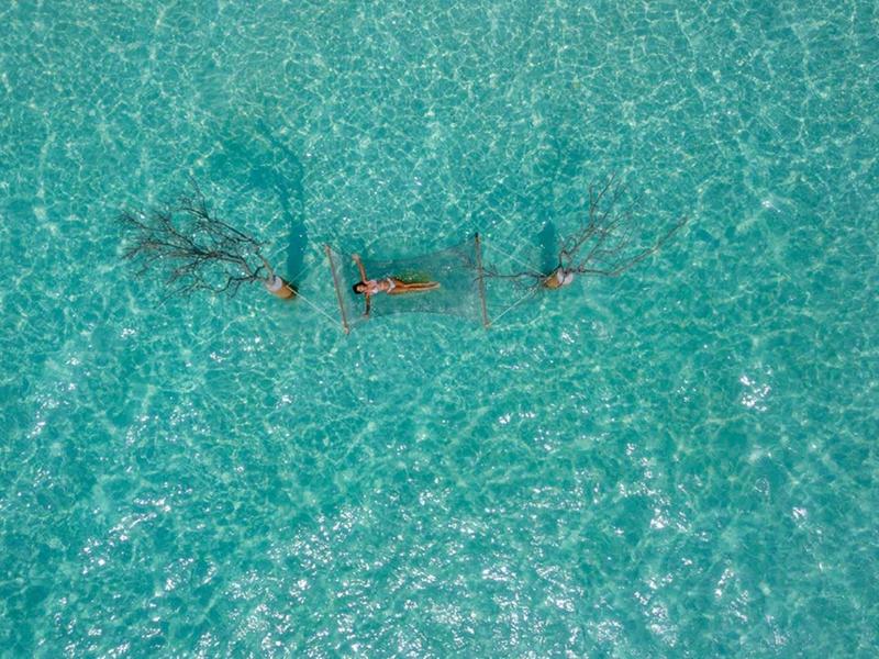 Klare türkisfarbene Wasseroberfläche mit zwei Menschen, die nebeneinander schwimmen.