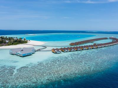Exclusive overwater bungalows on a tropical island with clear blue water and white sandy beach.