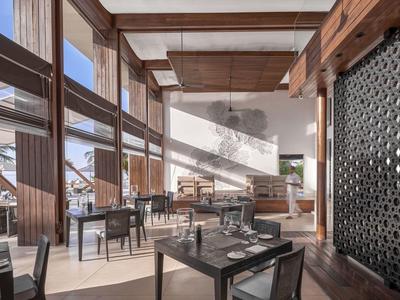 Restaurant moderne avec boiseries et grandes baies vitrées donnant sur la mer.