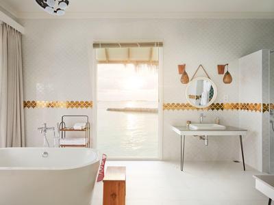 Modernes Badezimmer mit Badewanne und Fenster mit Meerblick in hellem Design.