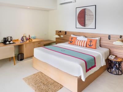 Modernes Hotelzimmer mit Doppelbett, Schreibtisch und minimalistischer Dekoration.