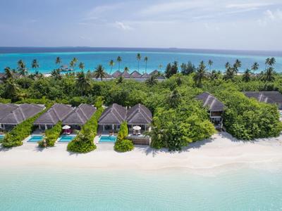 Tropisches Strandresort mit Hütten am weißen Sand und klarem Meerwasser.