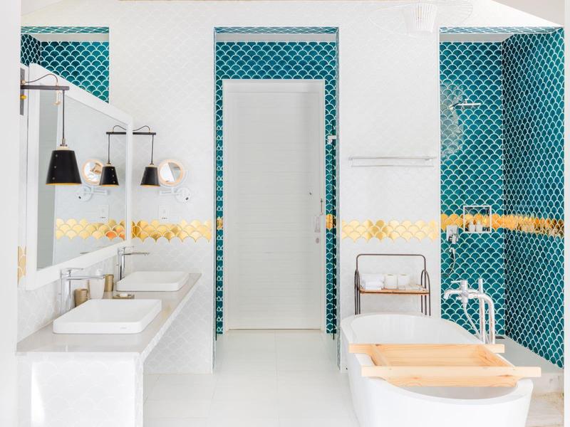 Moderner Badezimmerbereich mit Doppelwaschbecken und türkisfarbenen Fliesen.