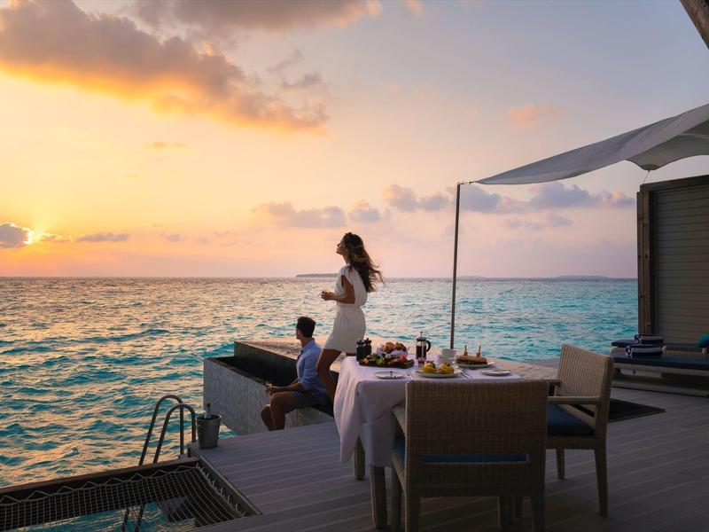 Cena romántica al atardecer en un muelle sobre el mar.
