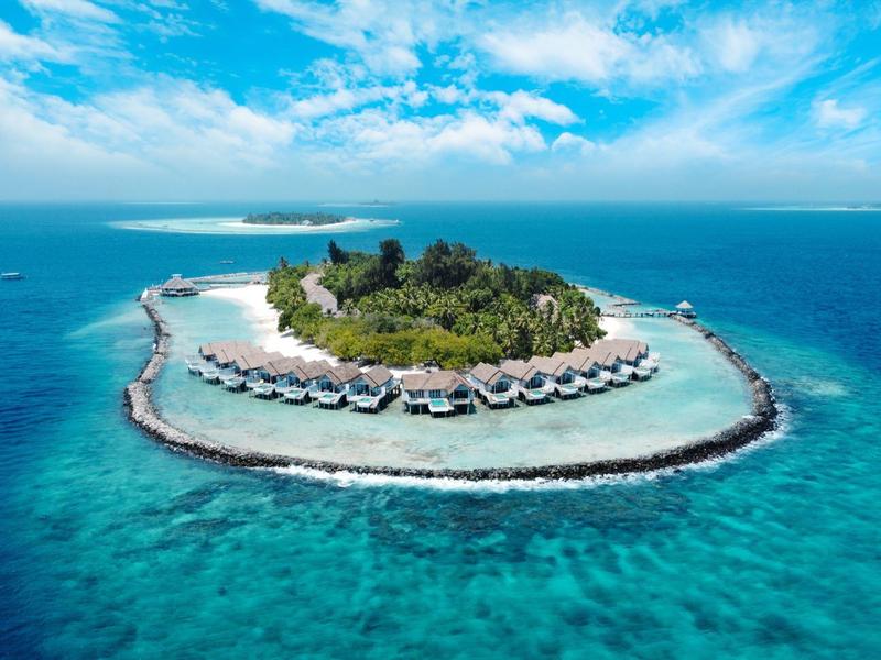 Luftaufnahme einer tropischen Insel mit Überwasser-Bungalows und türkisblauem Wasser