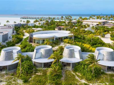 Bungalowy w tropikalnym kurorcie otoczone zielenią z widokiem na morze.