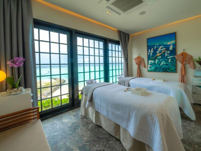 Przytulny pokój z dwoma łóżkami, dużymi oknami i widokiem na morze.