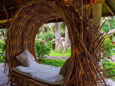 Gezellige zit van twijgen met kussens in een hoteltuin.