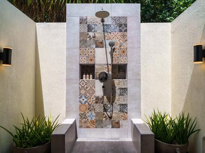 Moderne buiten douche met patroontegels en planten aan de zijkanten.