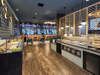 Ristorante a buffet moderno con pavimento in legno e ambiente luminoso.