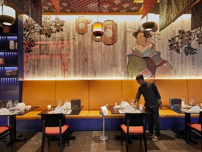 Modernes Restaurant mit Holzwänden, malerischer Wanddekoration und stilvollen Sitzplätzen.