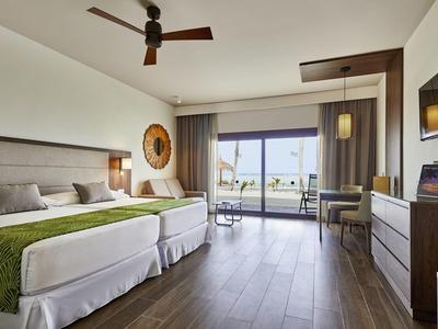 Modernes Hotelzimmer mit zwei Betten, Balkon und Meerblick, hell und einladend eingerichtet.