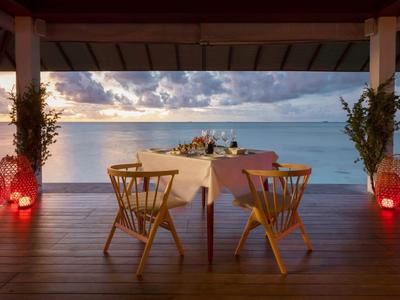 Cena romántica al aire libre con vista al mar y luces de linternas