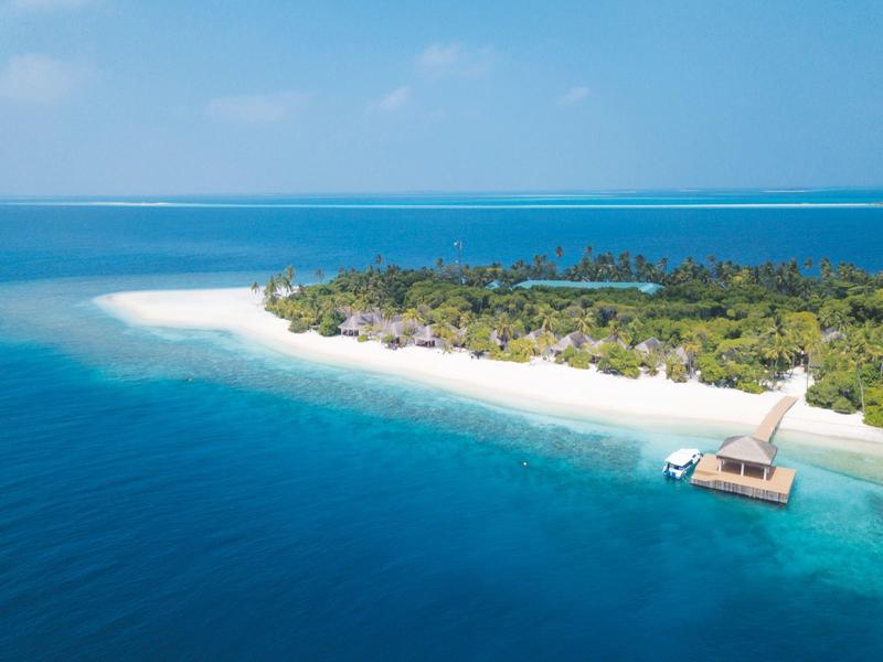 Luftaufnahme einer tropischen Insel mit weißem Sandstrand und klarem blauem Wasser.