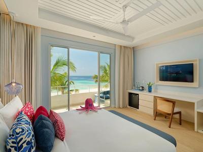 Habitación de hotel luminosa con vista al mar, terraza y decoración moderna.