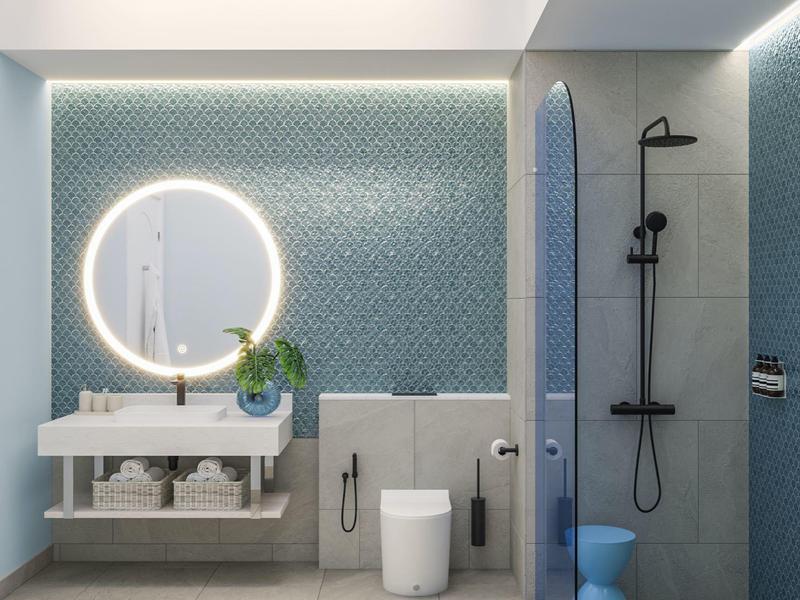 Modern bathroom with blue tiled wall, round illuminated mirror, and walk-in shower.