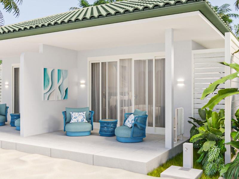 Modern outdoor patio with blue cushioned chairs and tropical greenery under a tiled roof.